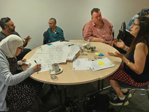  People discussing their reactions to the stories they have heard at a local knowledge exchange in Leeds.